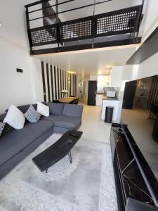 a living room with a blue couch and a table at Couleur océan, piscine et plage in Le Croisic