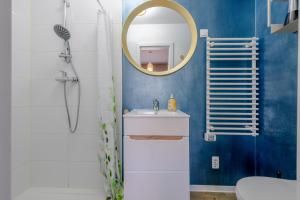 a bathroom with a sink and a mirror at Gemütliche Ferienwohnung - Araliya 2 in Ahlbeck +10 photos