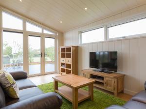 a living room with a couch and a television at Cedar Lodge in Hassocks