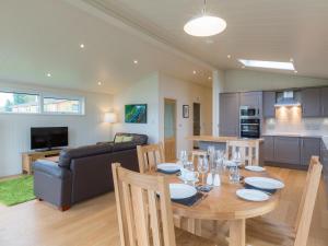 a dining room and living room with a table and a couch at Cedar Lodge in Hassocks