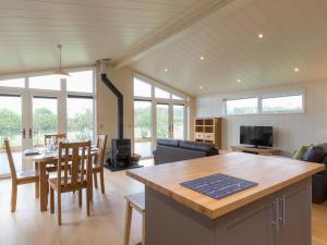 a kitchen and living room with a table and chairs at Cedar Lodge in Hassocks