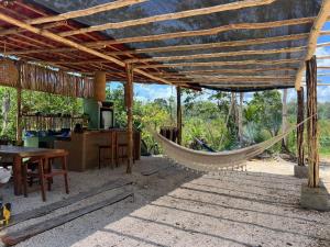 a hammock in a house with a kitchen and a table at Selva Morena in Felipe Carrillo Puerto