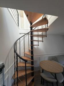 a spiral staircase in a room with a table at Duplex moderne hyper-centre Tout à pied in Thonon-les-Bains +1 photo
