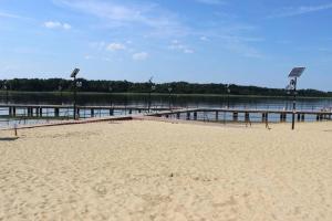 a sandy beach with a pier and a body of water at Brda Hideaway in Głębokie