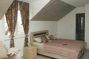 a bedroom with a bed and a window at Apartmani Romansa in Irig +11 photos