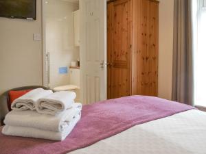 a pile of towels sitting on top of a bed at Eldin Hall Cottage 2 - Uk2484 in Scarborough