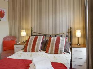a bedroom with a bed with two lamps and a chair at Eldin Hall Cottage 2 - Uk2484 in Scarborough +4 photos
