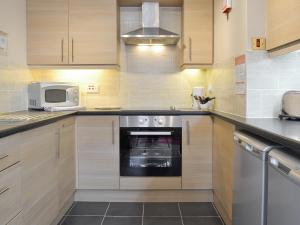 a kitchen with a stove and a microwave at Eldin Hall Cottage 2 - Uk2484 in Scarborough