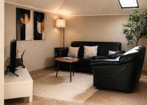a living room with a black couch and a table at Villa Motti Quadri in Arona