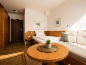a living room with a bed and a table at CityHotel Feuerbach in Stuttgart +11 photos