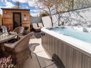 a hot tub on a patio with a table and chairs at The Helmsley Retreat in Helmsley