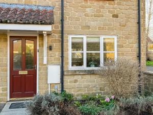 a brick house with a red door and a window at The Helmsley Retreat in Helmsley
