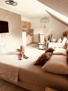 a teddy bear sitting on a bed in a bedroom at Apartmani Romansa in Irig