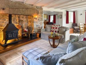 a living room with a couch and a fireplace at Prideaux Cottage in Par