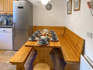 a kitchen with a wooden table with dishes on it at Prideaux Cottage in Par