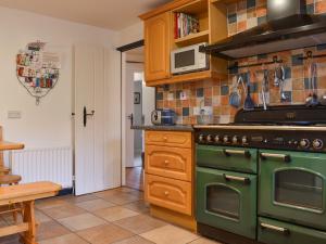 a kitchen with a green stove and a microwave at Prideaux Cottage in Par +29 photos