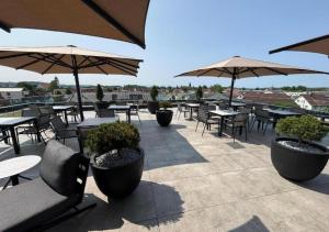 an outdoor patio with tables and chairs and umbrellas at Brera Meckenbeuren-Friedrichshafen in Meckenbeuren