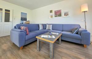 a blue couch in a living room with a table at Meiereikoppel 11 in Petersdorf auf Fehmarn