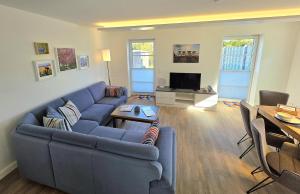 a living room with a blue couch and a tv at Meiereikoppel 11 in Petersdorf auf Fehmarn