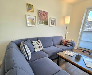 a blue couch in a living room with a table at Meiereikoppel 11 in Petersdorf auf Fehmarn