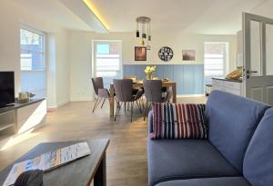 a living room with a blue couch and a table at Meiereikoppel 11 in Petersdorf auf Fehmarn
