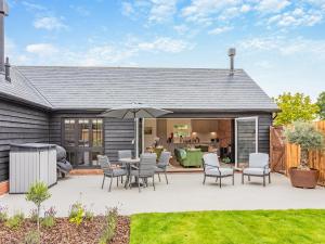 a patio with a table and chairs and an umbrella at Uk47692 - Wiggles Cottage in Wimbish