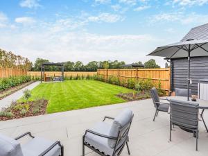 a patio with a table and chairs and a lawn at Uk47692 - Wiggles Cottage in Wimbish
