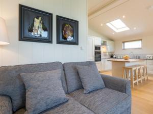 a living room with a couch and a kitchen at Maple Lodge in Hassocks