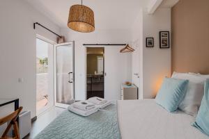 a bedroom with a white bed and a glass door at Cozy Suite À Da Marina in Quinta do Poço