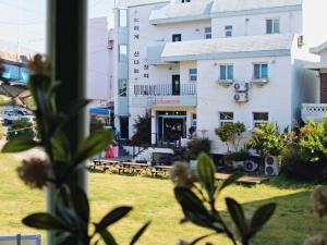 a view of a building from a yard with flowers at Suncheon Guest House Nreem in Suncheon