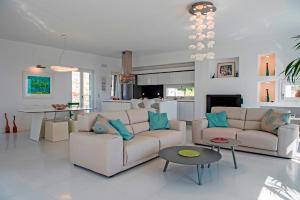 a living room with two couches and a kitchen at villa zakintos in Aspro Chorio Paros