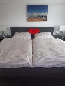 a bed with two pillows and a red heart on it at Ferienwohnung Engel in Romanshorn