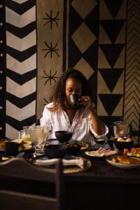 a woman sitting at a table eating food at Villa Bakari in Arraial d'Ajuda +142 photos