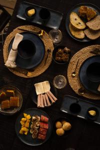 a wooden table with plates of food on it at Villa Bakari in Arraial d'Ajuda
