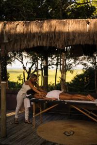 a man laying on a bed under a thatch roof at Villa Bakari in Arraial d'Ajuda