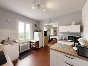 a kitchen with white cabinets and a counter top at La Bel'goudène proche des plages in Audierne +17 photos