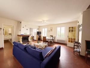 a living room with a blue couch and a table at La Bel'goudène proche des plages in Audierne