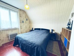 a bedroom with a bed in the corner of a room at La Bel'goudène proche des plages in Audierne