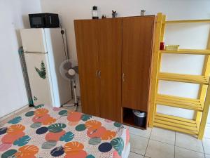 a room with a bed and a refrigerator and a cabinet at Chambres les pieds dans l’eau résidence Cypria in Les Trois-Îlets
