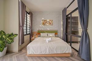 a bedroom with a bed and a potted plant at Doris Entire House Da Nang in Danang