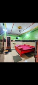 a room with a red bed and a green wall at Hotel Neelkamal Guest House in Rewa