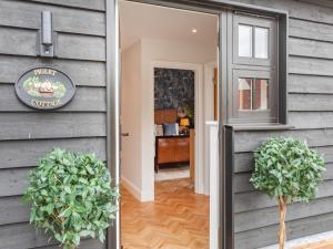a door to a house with two potted plants at Uk47693 - Piglet Cottage in Wimbish