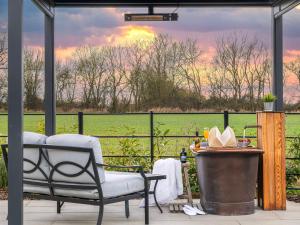 a patio with a chair and a view of a field at Uk47693 - Piglet Cottage in Wimbish