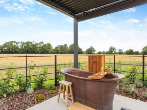 an old tub sitting on a patio with a view of a field at Uk47693 - Piglet Cottage in Wimbish +12 photos