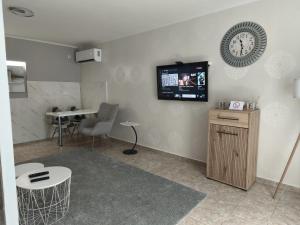 a waiting room with a tv on the wall and a table at Silver Spa Apartment in Bačka Palanka