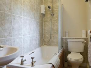 a bathroom with a tub and a toilet and a sink at Ross in Launceston