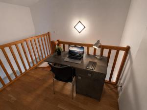 a desk with a laptop on it in a room at Duplex Kedge Talence in Talence