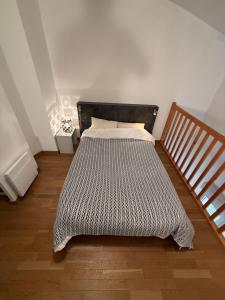a bed in a bedroom with a wooden floor at Duplex Kedge Talence in Talence