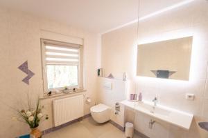 a bathroom with a toilet and a sink and a window at Ferienwohnung Familie Täubert in Klein Uhyst +14 photos