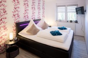 a bedroom with a bed with two blue pillows on it at Ferienwohnung Familie Täubert in Klein Uhyst